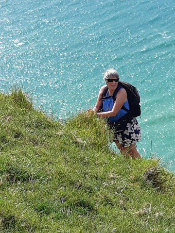 Debbie climbing the steep grassy slope
